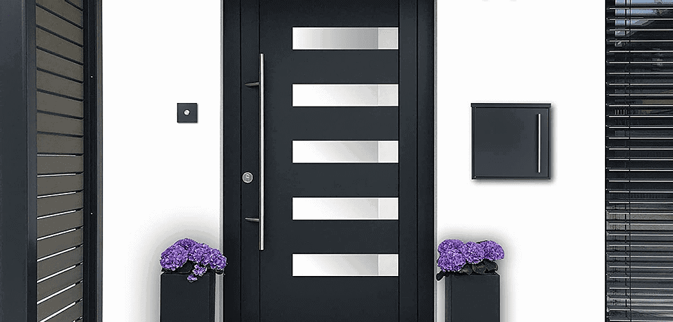 An iLoveParcels letter box mounted to a white wall next to a black foor with some purple flowers to either side